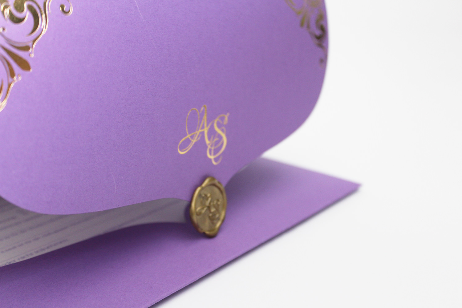 Lila Hochzeitseinladung mit goldenem Monogramm, Ornamenten und Wachssiegel, aufgestellt